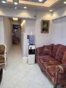 a living room with a couch and a small refrigerator at Serine Hostel in Alexandria