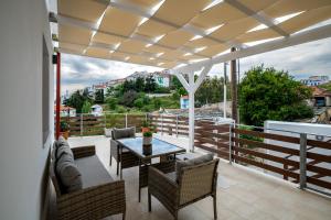 Un patio con una mesa y sillas en un balcón. en Angela's House, en Centro histórico de Alónnisos
