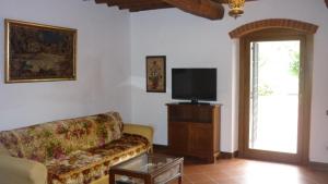 a living room with a couch and a tv at La Valle dei Gobbi in Monsummano Terme