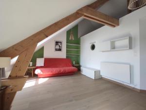 een slaapkamer met een rood bed en groene muren bij L'ancrage in Wimereux
