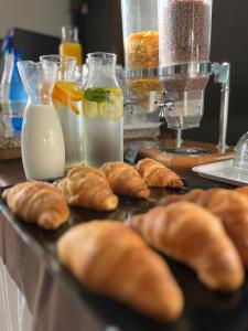 uma mesa com croissants e garrafas de leite em Hotel Rosapineta - Adults Only em Lignano Sabbiadoro