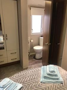 uma casa de banho com uma cama com toalhas em Seaview Retreat unavailabl3 em Mainsriddle