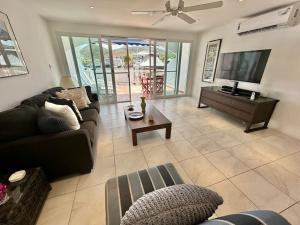 a living room with a couch and a tv at Villa 218E Jolly Harbour in Jolly Harbour
