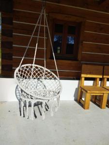 a basket swing hanging from a porch of a cabin at Nocuj in Teplice nad Metují
