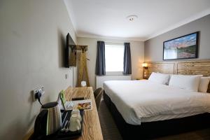 a hotel room with a bed and a table with a bed sidx sidx at Red Lion, Wigan by Marston's Inns in Rufford