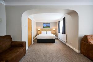 una camera d'albergo con letto e divano di Red Lion, Wigan by Marston's Inns a Rufford