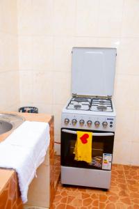 a kitchen with a stove with a towel on the door at Mella home Arusha in Marombosa +6 photos