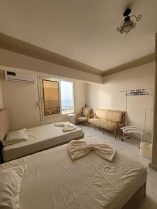 1 dormitorio con 2 camas, sofá y ventana en Serine Hostel en Alexandria
