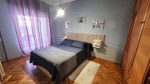 een slaapkamer met een bed met een houten hoofdeinde bij El Hogar de Todos in Ourense