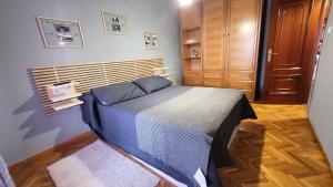 een kleine slaapkamer met een bed en een houten kast bij El Hogar de Todos in Ourense
