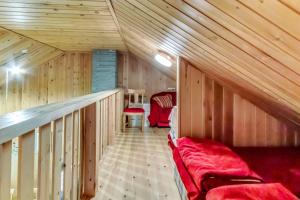 una camera con un divano rosso in una cabina di legno di Lomahuoneisto Suomukas 6 B a Suomutunturi