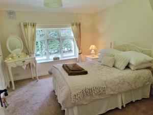 1 dormitorio con cama con espejo y mesa en Rooms at Ballysax House en The Curragh