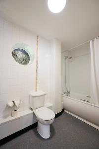 a bathroom with a toilet and a tub and a sink at Red Lion, Wigan by Marston's Inns in Rufford