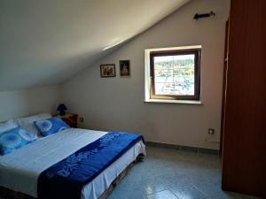 sypialnia z łóżkiem i oknem w obiekcie Apartmani Ela w Bibinje