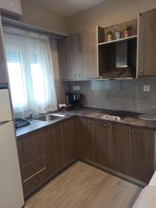 an empty kitchen with wooden cabinets and a sink at achlia beach apartments 1 in Ierapetra