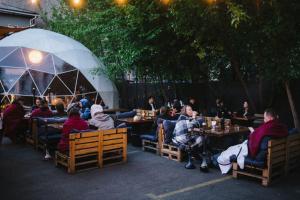 Eine Gruppe von Menschen sitzt an Tischen in einem Restaurant in der Unterkunft P2B hostel & bar in Kiew