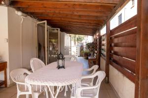 a white table and white chairs on a porch at Spyros No23 Charming Oceanview Maisonette in Meneou