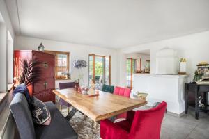 a living room with a wooden table and red chairs at Kitzchalet in Kitzbühel