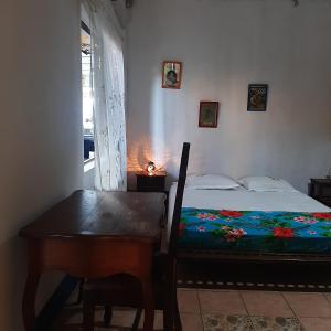 sypialnia z łóżkiem, stołem i biurkiem w obiekcie Les Alizés w mieście Antsiranana
