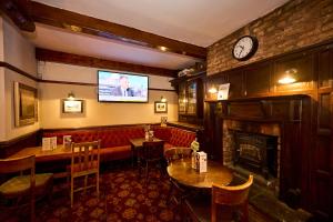 a restaurant with a fireplace and a tv on the wall at Red Lion, Wigan by Marston's Inns in Rufford