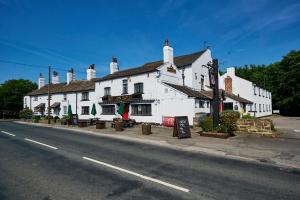 um grande edifício branco no lado de uma rua em Red Lion, Wigan by Marston's Inns em Rufford