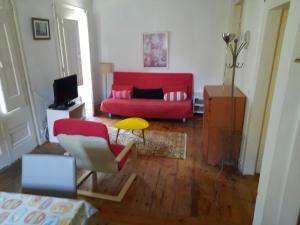 リスボンにあるInglesinhos Loftのリビングルーム(赤いソファ、テーブル付)