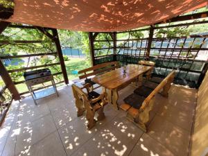 einen Holztisch und Stühle auf einer abgeschirmten Veranda in der Unterkunft Haus Seebrise in Faak am See