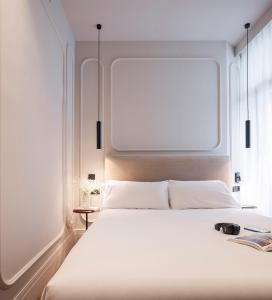 a bedroom with a white bed with a large window at Room Mate Oliveira - City Centre, Valencia in Valencia