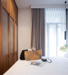 una camera d'albergo con un letto e una borsa sopra di Oliveira Rooms a Valencia