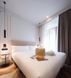 Un dormitorio con una gran cama blanca y una ventana en Oliveira Rooms, en Valencia