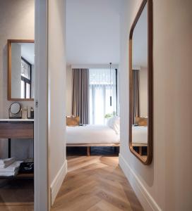 1 dormitorio con cama y espejo en Oliveira Rooms en Valencia