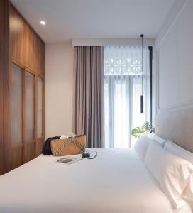a bedroom with a large white bed with a window at Oliveira Rooms in Valencia
