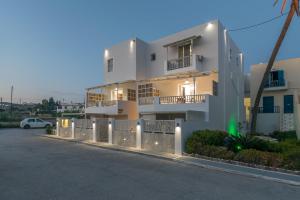 a white building with a fence in front of it at Orama Suites Milos in Adamantas