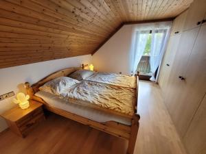 Cama en habitación con techo de madera en Haus Seebrise, en Faak am See