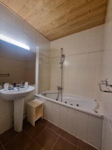 y baño con bañera, lavamanos y bañera. en Hotel Le Cairn, en Les Deux Alpes