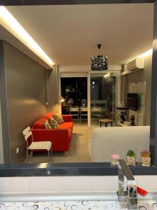 sala de estar con sofá rojo y mesa en Apartamento Alicante San Juan playa 1ª línea, en Benimagrell