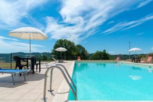 uma piscina com mesa e cadeiras e um guarda-sol em Villa Aurora em Monte Rinaldo
