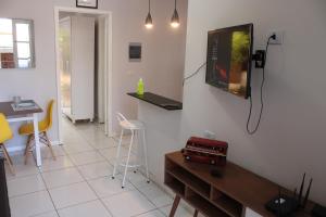 Casa Ourinhos Pet Friendly في أورينهوس: غرفة معيشة مع تلفزيون بشاشة مسطحة على جدار