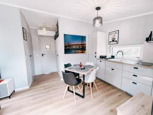 a kitchen with a table and chairs in a room at Domek Golf i Jezioro in Tomaszkowo