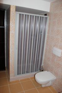 a bathroom with a toilet and a large window at La Maison Rouge b&b in Ginosa Marina