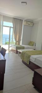 a bedroom with two beds and a view of the ocean at Deniz Hotel in Büyükçekmece