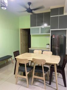 uma mesa e cadeiras numa cozinha com paredes verdes em NO 5 NAZIRIN HOMESTAY Tmn Desa Manjung em Lumut