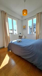 a bedroom with a large bed in a room with windows at Les Matelots Rouen Centre by MyFrenchPAT in Rouen