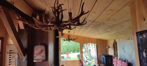 d'un grand lustre en bois suspendu au plafond d'une pièce. dans l'établissement Domaine le lanis "cabane de Pauline", à Saint-Girons