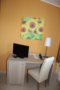 a desk with a computer and a chair in a room at La Maison Rouge b&b in Ginosa Marina