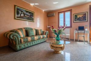 a living room with a couch and a glass table at Casa Vacanza Germano - Vivi un soggiorno da sogno - 160m2 di comfort e vista mare in Sicilia! in Pachino