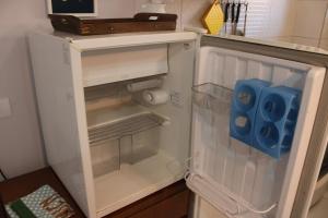 an empty refrigerator with its door open in a kitchen at Casa Ourinhos Pet Friendly in Ourinhos