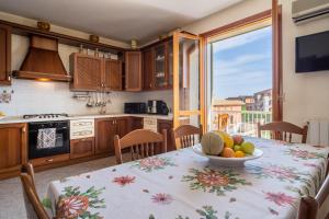 una cucina con tavolo e ciotola di frutta di Casa Vacanza Germano - Vivi un soggiorno da sogno - 160m2 di comfort e vista mare in Sicilia! a Pachino