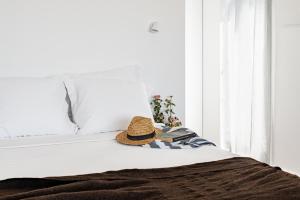 a hat sitting on top of a bed at Tres Marias in Vila Nova de Milfontes