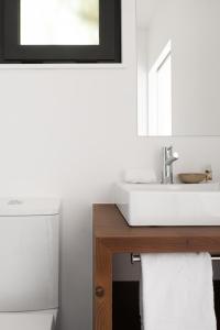 a white bathroom with a sink and a mirror at Tres Marias in Vila Nova de Milfontes